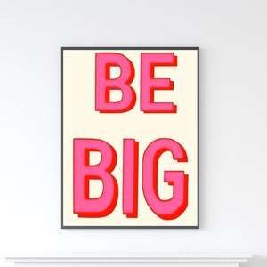 May include: A white framed poster with the words "BE BIG" in pink letters on a cream background.