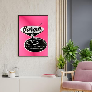 Puede incluir: Un p&oacute;ster rosa y negro con el texto "Baron's" en una fuente estilizada. El p&oacute;ster presenta una copa de martini con un tallo negro y un c&iacute;rculo negro con el texto "The Bar on Powell" y "Powell & O'Farrell Sts. San Francisco".