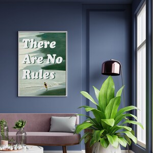May include: A framed print with a green and blue background featuring a person walking on a beach. The text "There Are No Rules" is written in white letters.