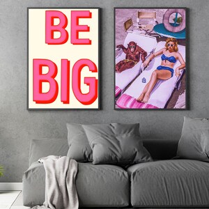 May include: Two framed prints, one with the text "BE BIG" in pink letters on a white background, and the other with a woman in a blue bikini laying on a lounge chair with a monkey sitting on another lounge chair.