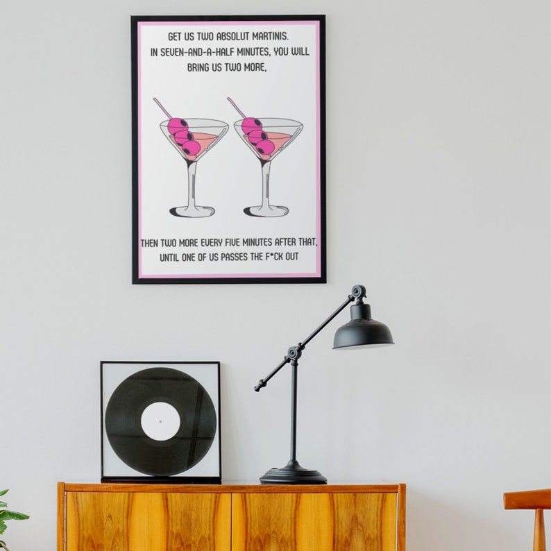May include: A black and white framed print with a pink background featuring two martini glasses with pink olives and the text "GET US TWO ABSOLUT MARTINIS. IN SEVEN-AND-A-HALF MINUTES, YOU WILL BRING US TWO MORE, THEN TWO MORE EVERY FIVE MINUTES AFTER THAT, UNTIL ONE OF US PASSES THE F*CK OUT"