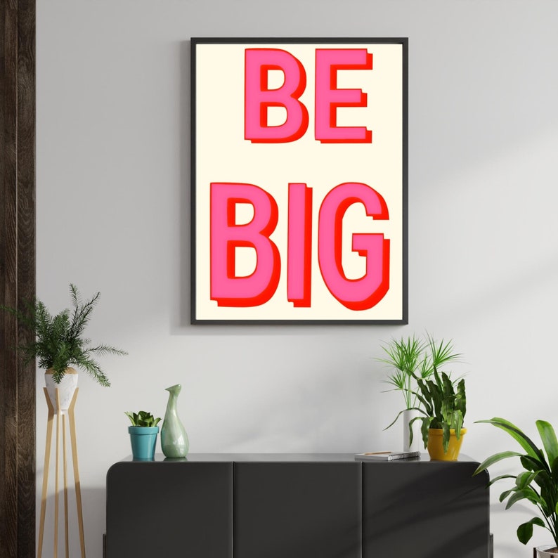 May include: A framed print with a white background and the words "BE BIG" in pink letters with a red outline.
