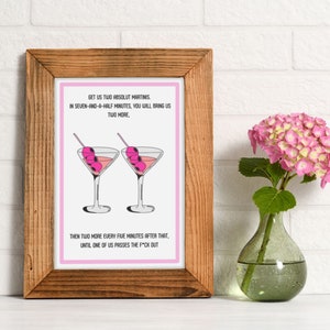 May include: A pink framed print with a white background and black text that reads "GET US TWO ABSOLUT MARTINIS. IN SEVEN-AND-A-HALF MINUTES, YOU WILL BRING US TWO MORE, THEN TWO MORE EVERY FIVE MINUTES AFTER THAT, UNTIL ONE OF US PASSES THE F*CK OUT". The print features two pink martini glasses with green olives.