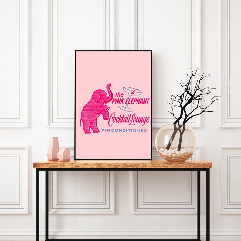 May include: A pink poster with a black frame featuring a pink elephant illustration with the text "the PINK ELEPHANT Cocktail Lounge AIR CONDITIONED".