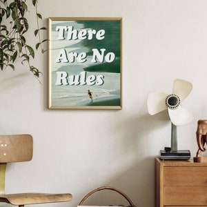 May include: A framed print with a green and blue beach scene and the text "There Are No Rules" in white. A person is running on the beach.