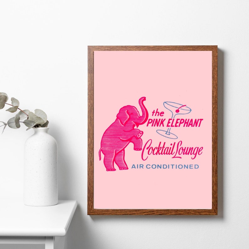 May include: A pink elephant illustration with its trunk raised, holding a martini glass with a cherry. The text reads "the PINK ELEPHANT Cocktail Lounge AIR CONDITIONED".