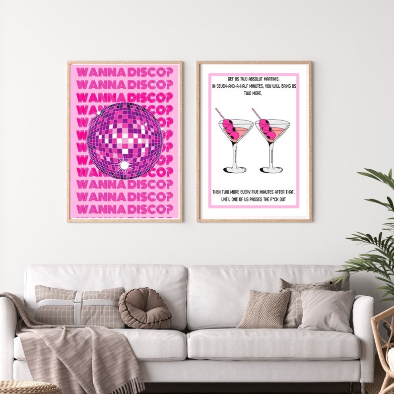 May include: Two pink framed prints with white text and illustrations. The left print features a disco ball and the text "Wanna Disco?" repeated multiple times. The right print features two martini glasses with olives and the text "Get us two Absolut Martinis in seven-and-a-half minutes, you will bring us two more. Then two more every five minutes after that, until one of us passes the f*ck out."