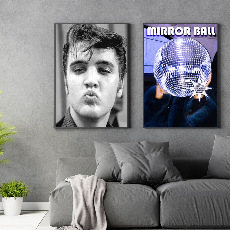 May include: Two framed posters, one with a black and white photo of Elvis Presley, the other with a disco ball and the text "MIRROR BALL" in purple letters. The text below the disco ball reads "I'll show you every version of yourself."
