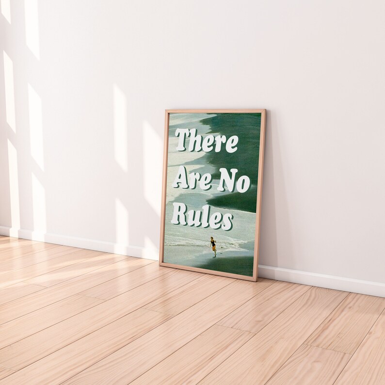 May include: A framed print with a green and white background featuring the text "There Are No Rules" in white. A person is walking on a beach in the background.