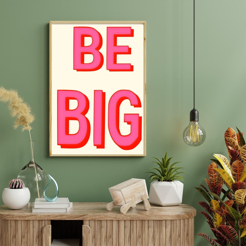 May include: A framed print with a white background and the words "BE BIG" in pink letters with red outlines.