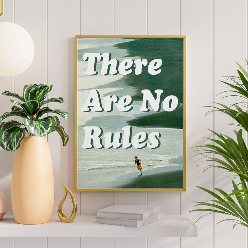 May include: A framed print with a green and blue beach scene and the text "There Are No Rules" in white. A person in a swimsuit is running on the beach.