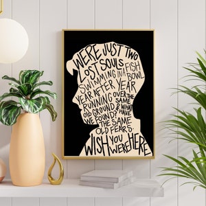 May include: Black and white typography art print with a silhouette of a person's head. The text reads "Were just two lost souls fish swimming in a year after year running over the old ground & what we found? Have the same old fears. Wish you were here."
