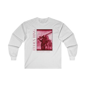 May include: White long-sleeve t-shirt with a red graphic of a character from the video game Elden Ring. The graphic includes a sword and the text "Elden Ring". The text below the graphic reads "Time we, you're strong of arm, but ask yourself... What harm can be done, to a shadow?"