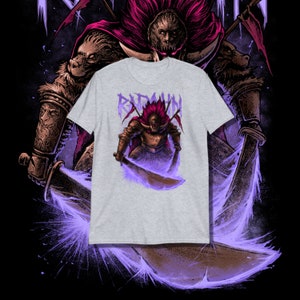 May include: A grey t-shirt with a graphic of a warrior in armor holding a sword. The warrior is surrounded by a purple glow. The text "Radahn" is above the warrior.