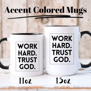 May include: Two white accent-colored mugs with black handles and rims. The mugs have the text "WORK HARD. TRUST GOD." in a black box. The smaller mug is 11oz, and the larger mug is 15oz. The words "Accent Colored Mugs" are at the top.