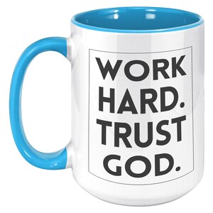 May include: White ceramic mug with a blue interior and handle. The mug features the text "WORK HARD. TRUST GOD." in a black, bold font, centered on the front. The mug is designed for hot beverages.