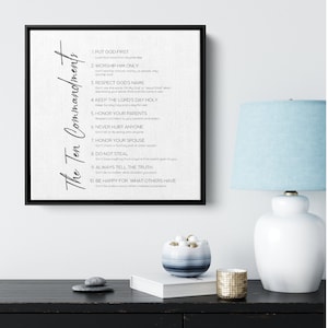 May include: A black and white framed print with the text "The Ten Commandments" and a list of the ten commandments. The background is a light gray canvas texture.