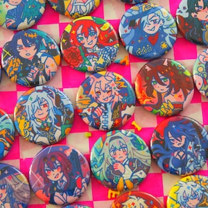 Puede incluir: Una colección de botones redondos y coloridos con ilustraciones de personajes de estilo anime. Los botones presentan varios personajes con diseños detallados, colores vibrantes y un acabado brillante. Están dispuestos sobre una superficie a cuadros rosa y blanco.