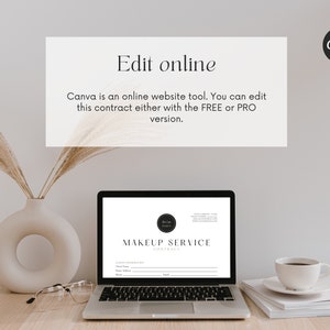 May include: A laptop computer displaying a makeup service contract template on the screen. The contract template has a black and white logo with the text "MAKEUP SERVICE CONTRACT". The laptop is on a wooden table with a vase of dried pampas grass, a pair of glasses, and a stack of white papers with a white coffee cup on top.