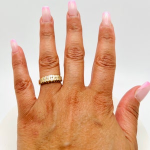 May include: A gold band ring with a row of small diamonds set in the band.