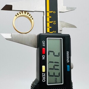 May include: A digital caliper measuring a gold ring with a textured surface. The reading on the display shows 2.15 mm.