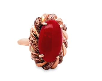 May include: A red coral ring set in a gold band with a twisted design.