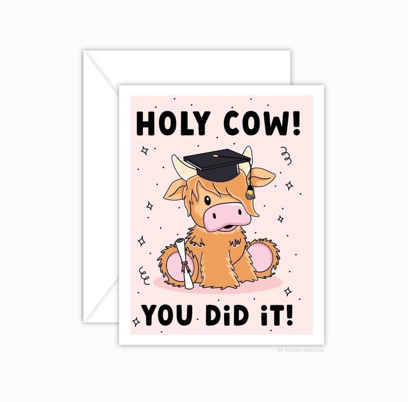 May include: A graduation card featuring a cartoon highland cow wearing a graduation cap and holding a diploma. The card has a pink background with white stars and the text "HOLY COW! YOU DID IT!"