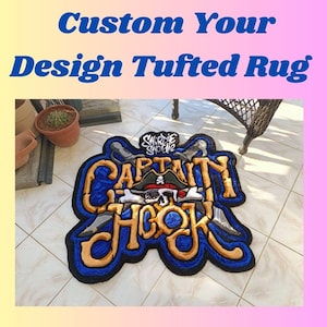 May include: A blue and gold tufted rug with the words "Captain Hook" and "Shorty Shordie" in a pirate-themed design.
