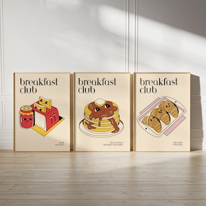 May include: Three illustrations of breakfast foods with the text "breakfast club" above each. The first illustration shows a toaster with bread and a jar of jam. The second illustration shows a stack of pancakes with a smiling face and a pat of butter. The third illustration shows a baking dish with three croissants.