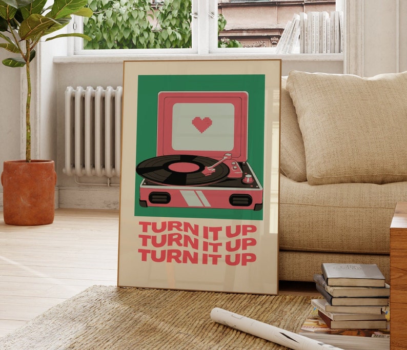 May include: A retro-style record player with a pink and green color scheme. The record player has a heart-shaped design on the front and the text "TURN IT UP" repeated three times.