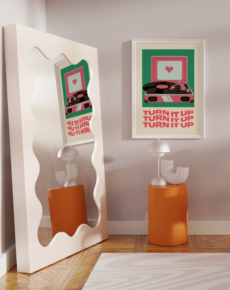 May include: A white framed print with a green background and a pink record player with a heart on the speaker. The text on the print reads "Turn it up, Turn it up, Turn it up".