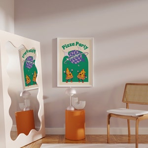 May include: A framed print with the words "Pizza Party" in green and white. The artwork features two cartoon pizza slices dancing under a purple and checkered planet. The background is a light beige color.