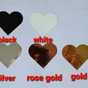 May include: Five heart-shaped stickers in different colours: black, white, silver, rose gold, and gold.
