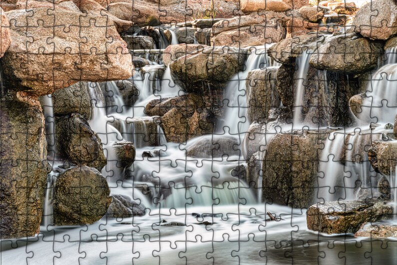 Waterfall Print wall art instant download of a soft waterfall gently flowing over the rocks in a mockup of the image printed on a puzzle.