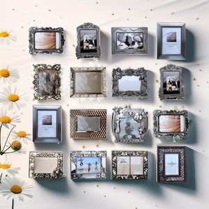 May include: A collection of 14 silver and gold picture frames with ornate designs. The frames are arranged in a grid pattern on a white background. Some of the frames have photos inside, while others are empty.