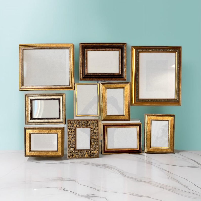 May include: A selection of ten picture frames in various sizes and styles. The frames are mainly gold and brown, with decorative detailing. The frames are arranged against a light blue backdrop.
