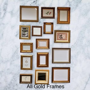May include: An assortment of gold-coloured picture frames in different shapes and sizes, displayed against a white and grey marbled backdrop. Some frames hold artwork or mirrors, others are empty. The text "All Gold Frames" is at the bottom.