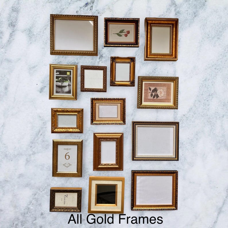 May include: An assortment of gold-coloured picture frames in different shapes and sizes, displayed against a white and grey marbled backdrop. Some frames hold artwork or mirrors, others are empty. The text "All Gold Frames" is at the bottom.