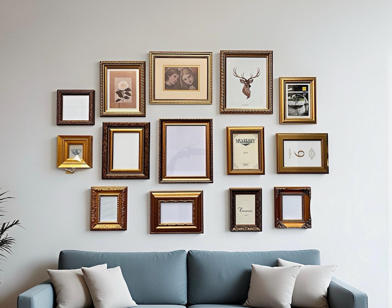 May include: An assortment of framed pictures and art pieces in decorative gold and brown frames. The frames are arranged on a light grey wall above a blue sofa with white cushions. The frames are empty or contain artwork.