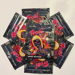 May include: Several black and red Trolli gummy candy packages. Each package features the text "James Harden Collector Edition" and "Trolli" in a stylized font. The packages also display a shoe graphic and the text "GUMMI CANDY NET WT 4.25 OZ (120g)".