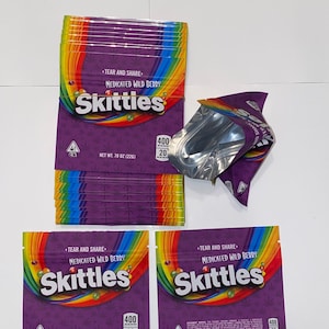 May include: A stack of purple and rainbow-colored bags with the text "Skittles" and "Medicated Wild Berry". The bags have a rainbow design and the text "Tear and Share". Each bag is labeled with "Net wt. 78 oz (226g)".