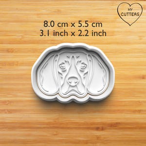 Könnte beinhalten: Ein weißer Ausstechform in Form eines Hundegesichts mit detaillierter Schnauze und Schlappohren. Der Text darüber lautet 8,0 cm x 5,5 cm und 3,1 inch x 2,2 inch, mit einem Herzlogo und dem Text MY CUTTERS in der oberen rechten Ecke.