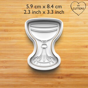 Könnte beinhalten: Weißer Plastik-Ausstecher in Form eines Kelches oder Pokals. Der Ausstecher ist 5,9 cm x 8,4 cm groß.