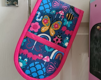May include: A pink and blue oven mitt with a colourful pattern of butterflies, ladybirds, ants, and rainbows. The mitt is hanging on a door handle.