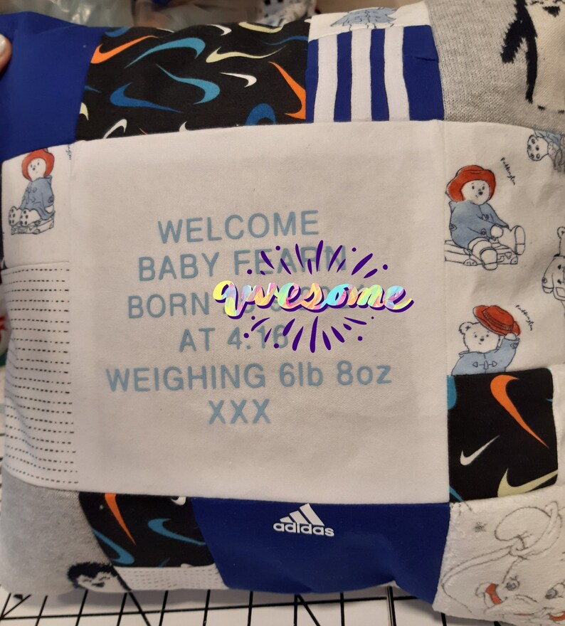 May include: A square patchwork memory cushion featuring various fabric patterns including blue, black, and white sections. The centre white panel displays the text: WELCOME BABY FEAM BORN AT 4:16 WEIGHING 6lb 8oz XXX. Includes logos for Nike and Adidas.