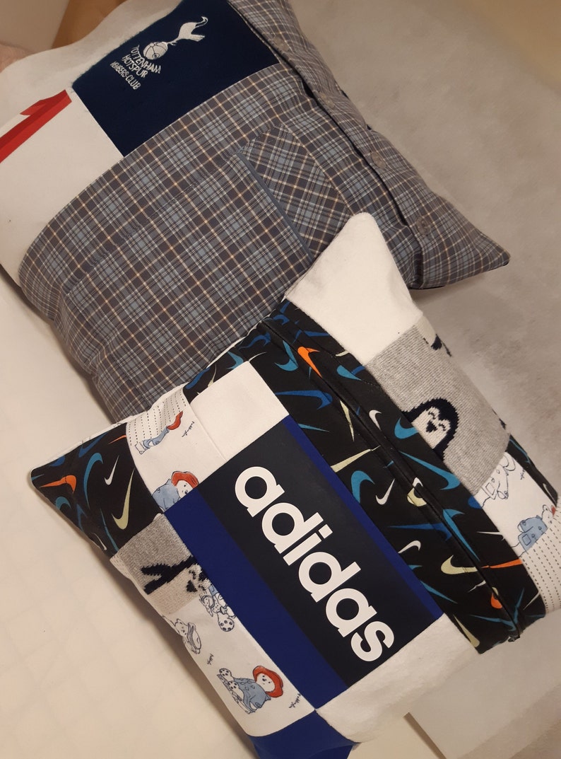 May include: Two square scatter cushions constructed from various fabric patches. One cushion features a blue Tottenham Hotspur logo, while the other displays a prominent white adidas logo on a blue background, surrounded by patterned fabric panels.
