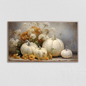 Puede incluir: Una pintura de bodegón con cuatro calabazas blancas de diferentes tamaños, rodeadas de un ramo de flores blancas y naranjas. Las calabazas están dispuestas sobre una superficie de madera con pétalos de flores esparcidos.