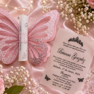 Puede incluir: Un tarjetero rosa con purpurina en forma de mariposa, un pergamino de papel enrollado y una tarjeta de invitación rectangular translúcida con texto negro, un icono de corona y gráficos de mariposas para la quinceañera de Brianna Gonzalez.