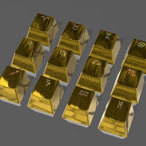 May include: Twelve gold bars, each with a different zodiac symbol engraved on top. The symbols are in various colors, including red, green, and brown. The bars are arranged on a gray surface.
