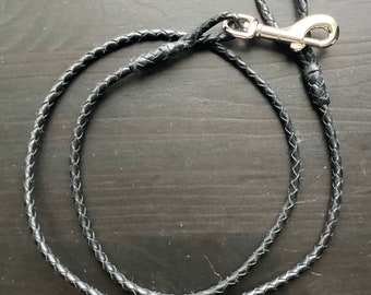 May include: A black leather braided dog leash with a silver clip.